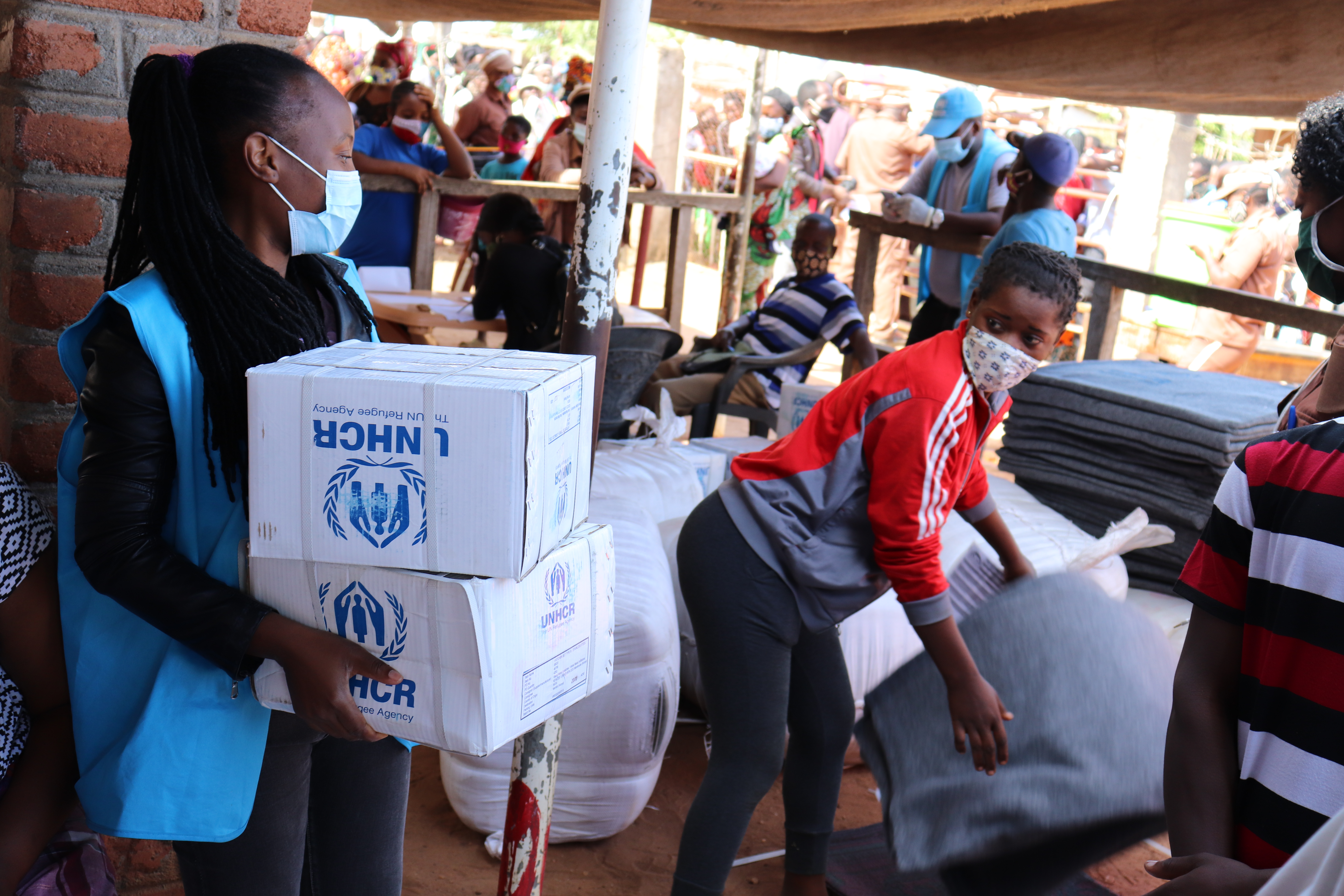 Natalia Inacia Jaime Alifoi (left), UN Volunteer Community Services Assistant with UNHCR in Mozambique, distributes blankets and cooking kits for refugee families, and sanitary napkins and soap for girls and women. (UNV, 2020)
